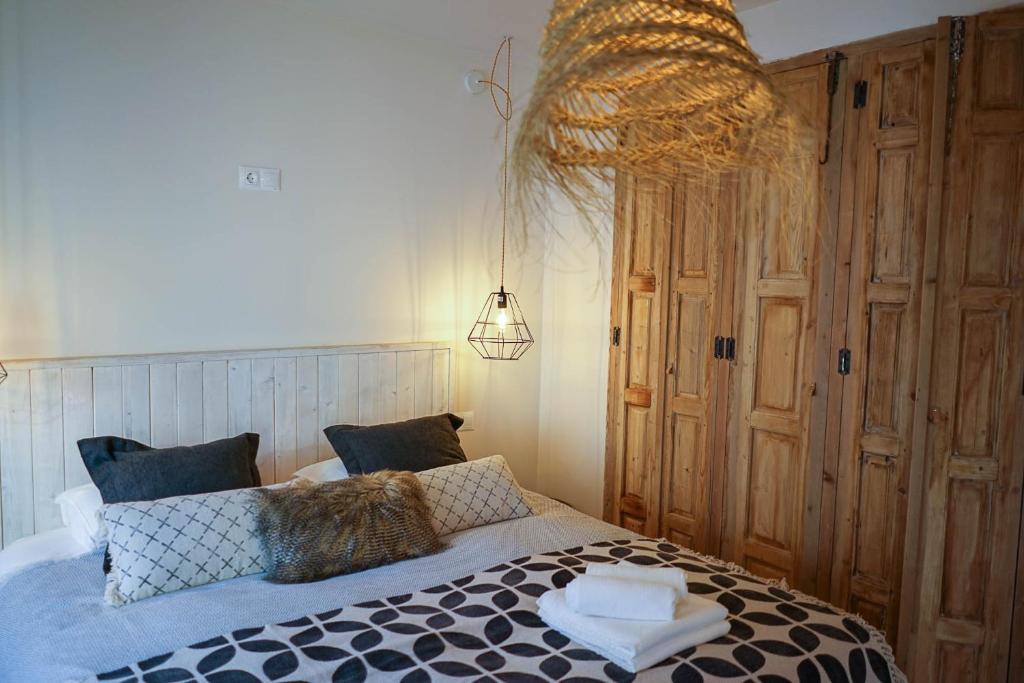 a bedroom with a bed and a chandelier at Ronda Center Apartments with Pool in Ronda