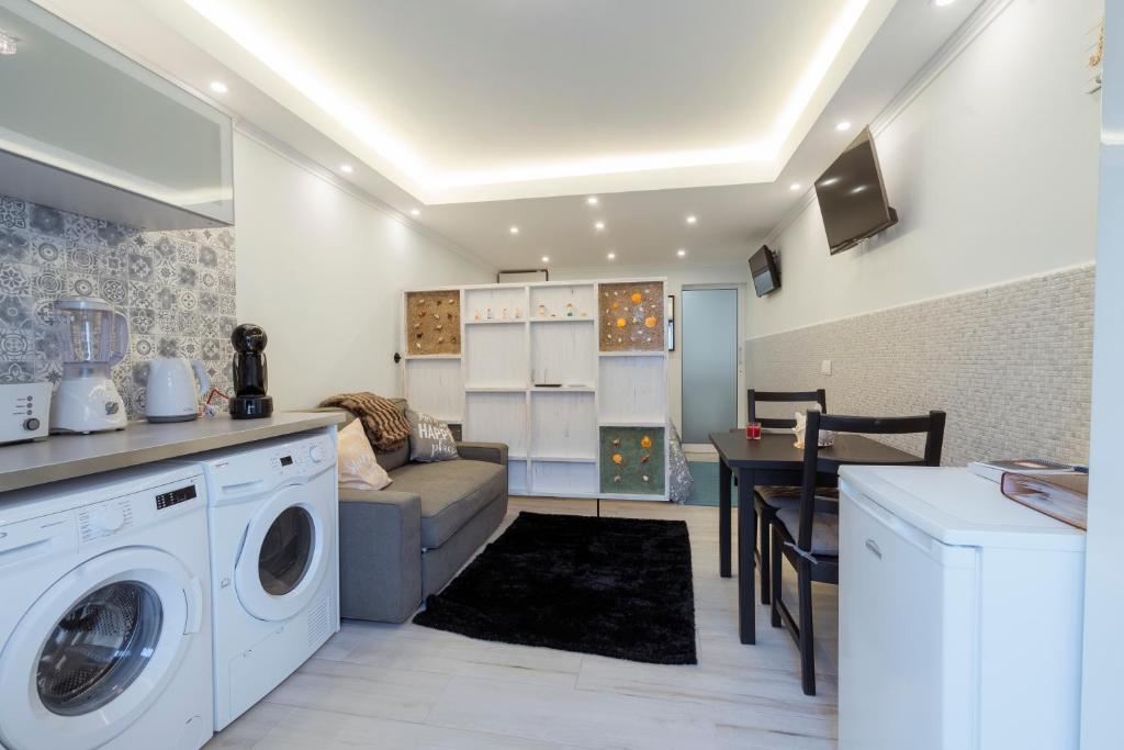 a kitchen and living room with a washer and dryer at Central Praia Beach in Praia da Vitória