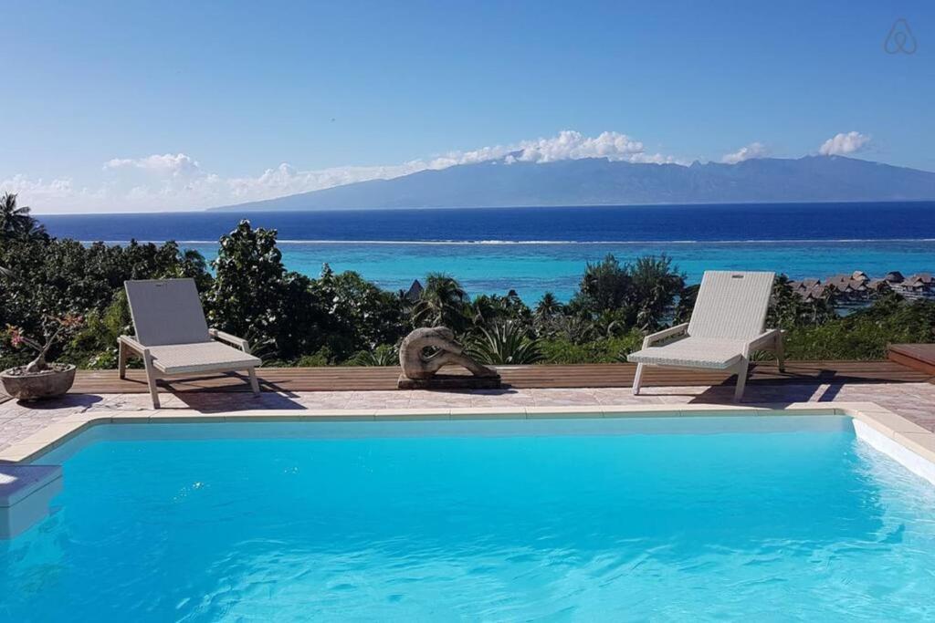 a swimming pool with two chairs and a view of the ocean at Villa Ora in Teavaro