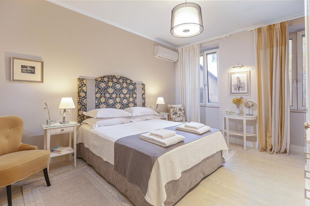 sypialnia z łóżkiem i dwoma ręcznikami na nim w obiekcie Palazzino Leone - Corfu Old Town Liston Deluxe Apartment w Korfu