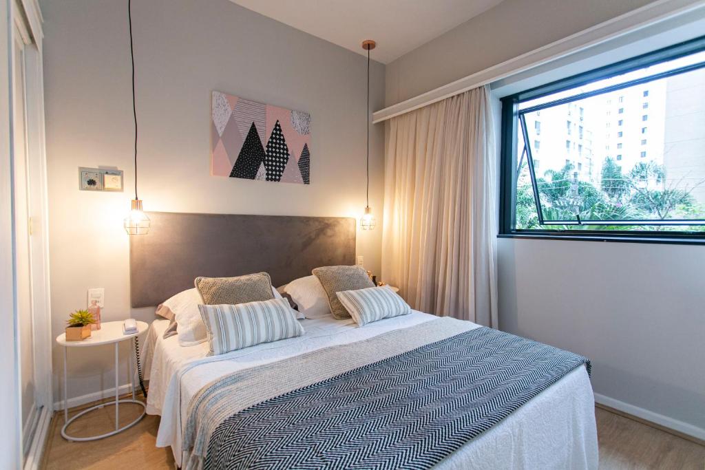 Un dormitorio con una cama grande y una ventana en Flat Jardins, excelente localização !, en São Paulo