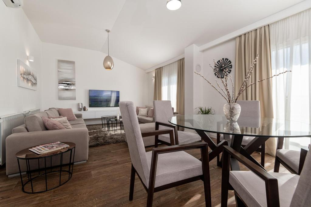 a living room with a glass table and a couch at Iva Apartment in Makarska
