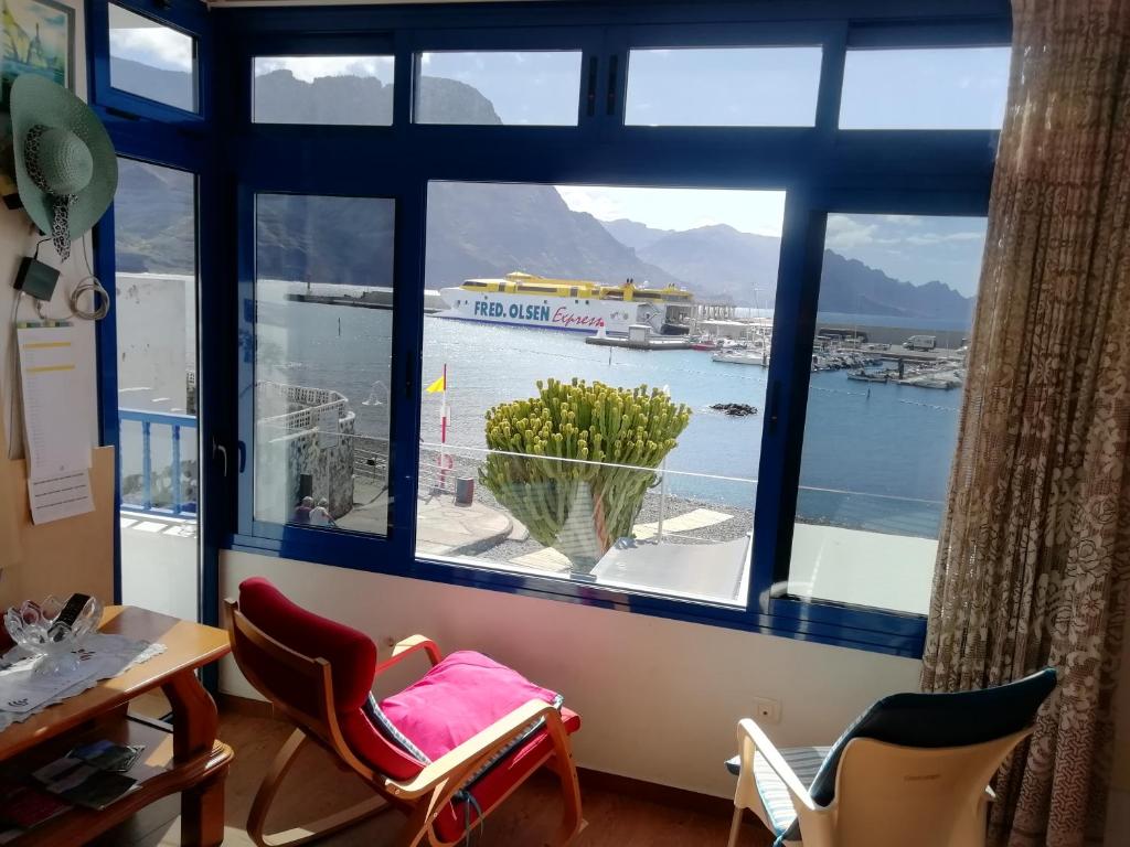 een kamer met een groot raam met uitzicht op een haven bij CasaPello SEAVIEW in Puerto de las Nieves