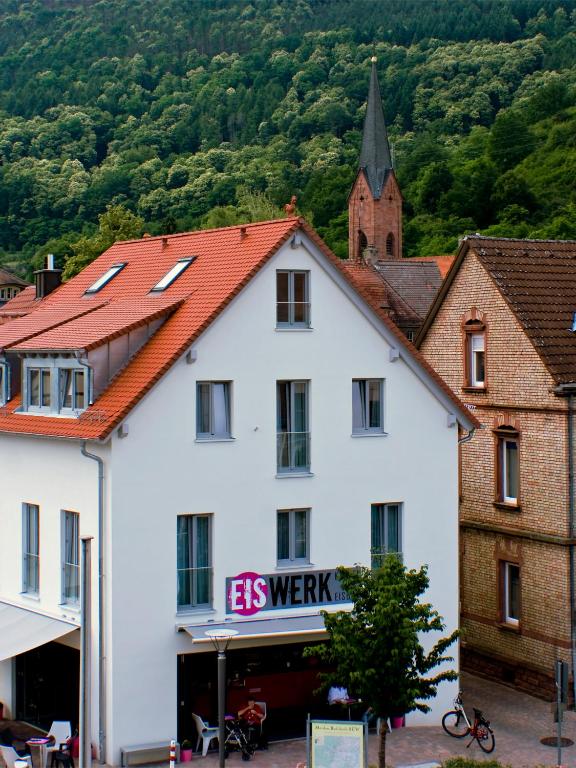 a white building with a red roof in a town at Gästehaus Eschers Eiswerk in Annweiler am Trifels