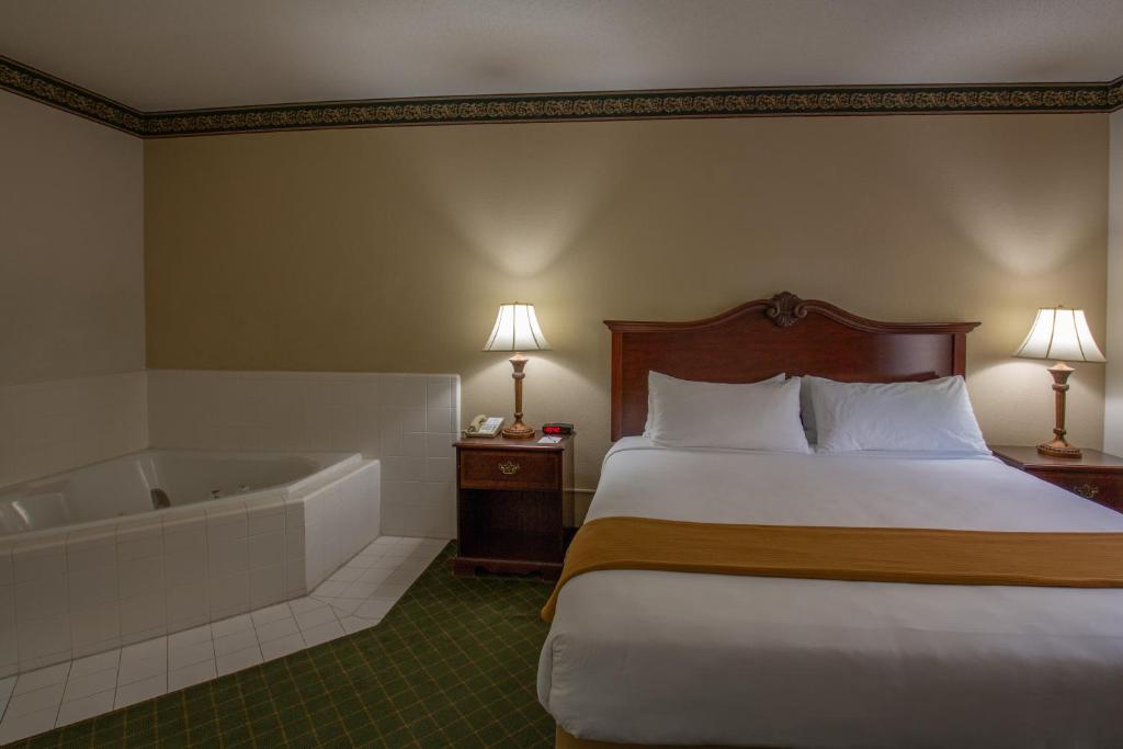 a hotel room with a bed and a bath tub at Moncks Corner Inn in Moncks Corner