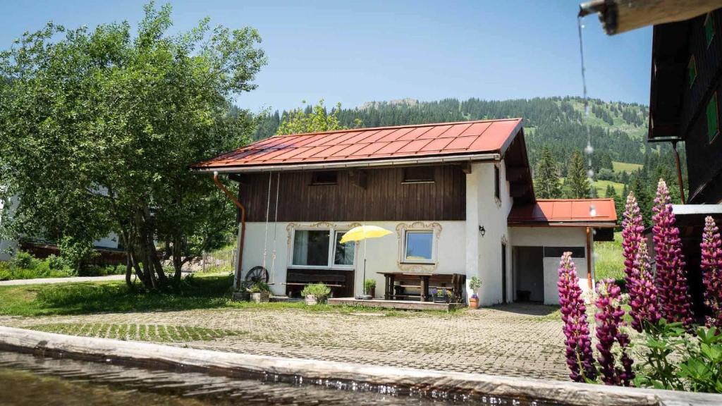 a small house with a red roof and a table at Ferienhaus Bausch in Balderschwang