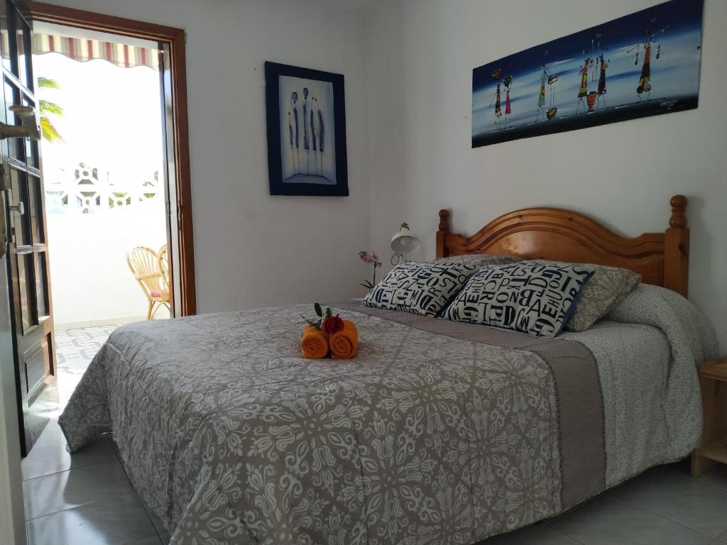 Un dormitorio con una cama con dos calabazas. en Apartamentos Playa Honda en Mácher