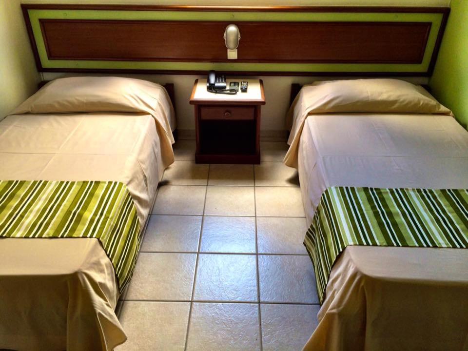Princetel Palace Hotel في لوندرينا: غرفة فندقية بسريرين وطاولة