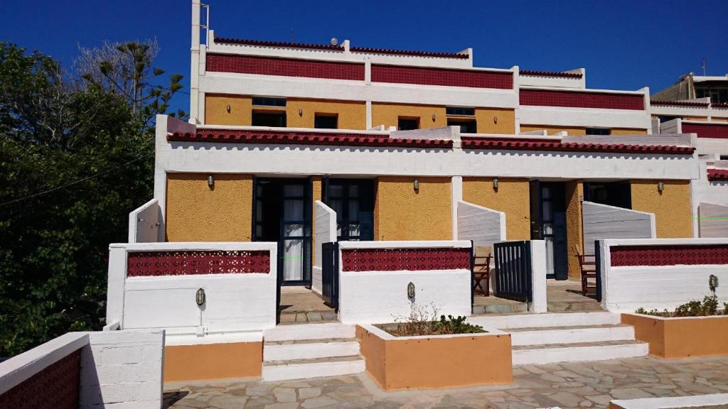 a yellow and white building with some plants in front at Mare Vista Hotel - Epaminondas in Batsi