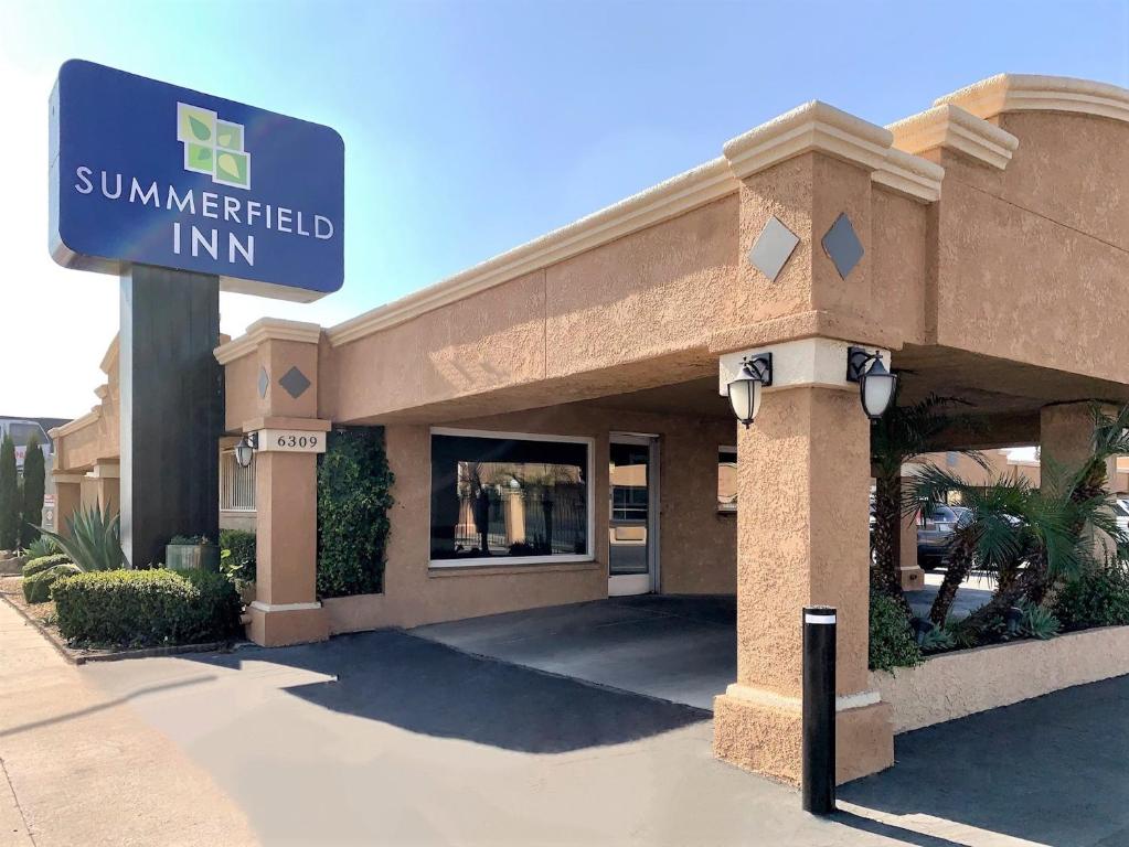 a sun interpreted inn sign in front of a building at Summerfield Inn Fresno Yosemite in Fresno