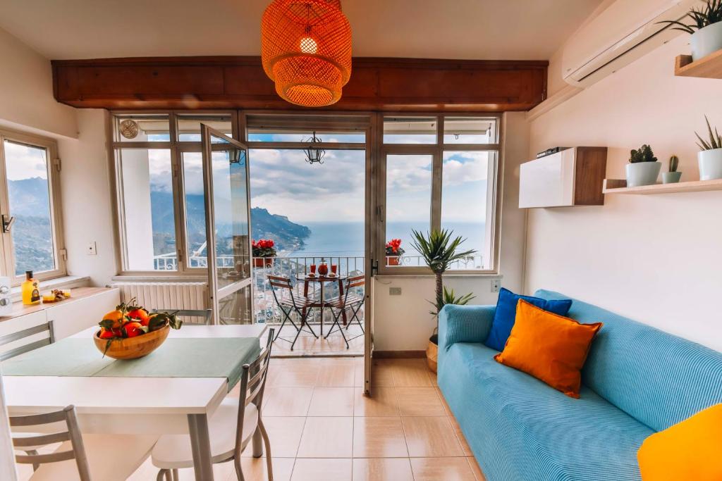 a living room with a blue couch and a table at CASA CHIARINA breathtaking sea view in Ravello