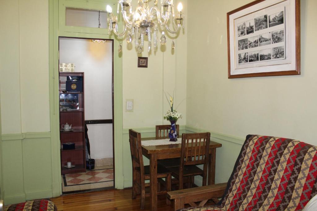 comedor con mesa, sillas y lámpara de araña en Apartment Castillo en Buenos Aires