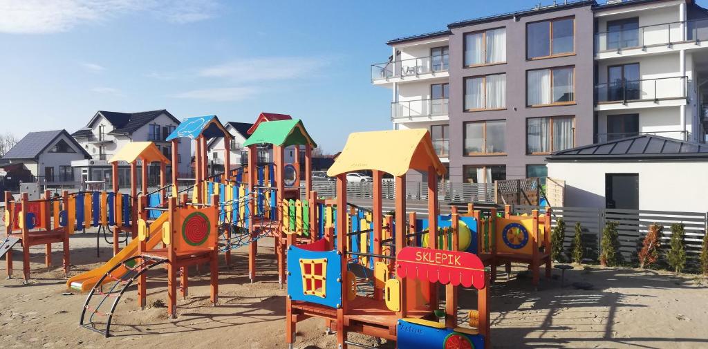 a row of colorful playground equipment in front of a building at Sarbinowo - ,,Apartament 32 u Ewy,, duży , całoroczny z Basenem in Sarbinowo