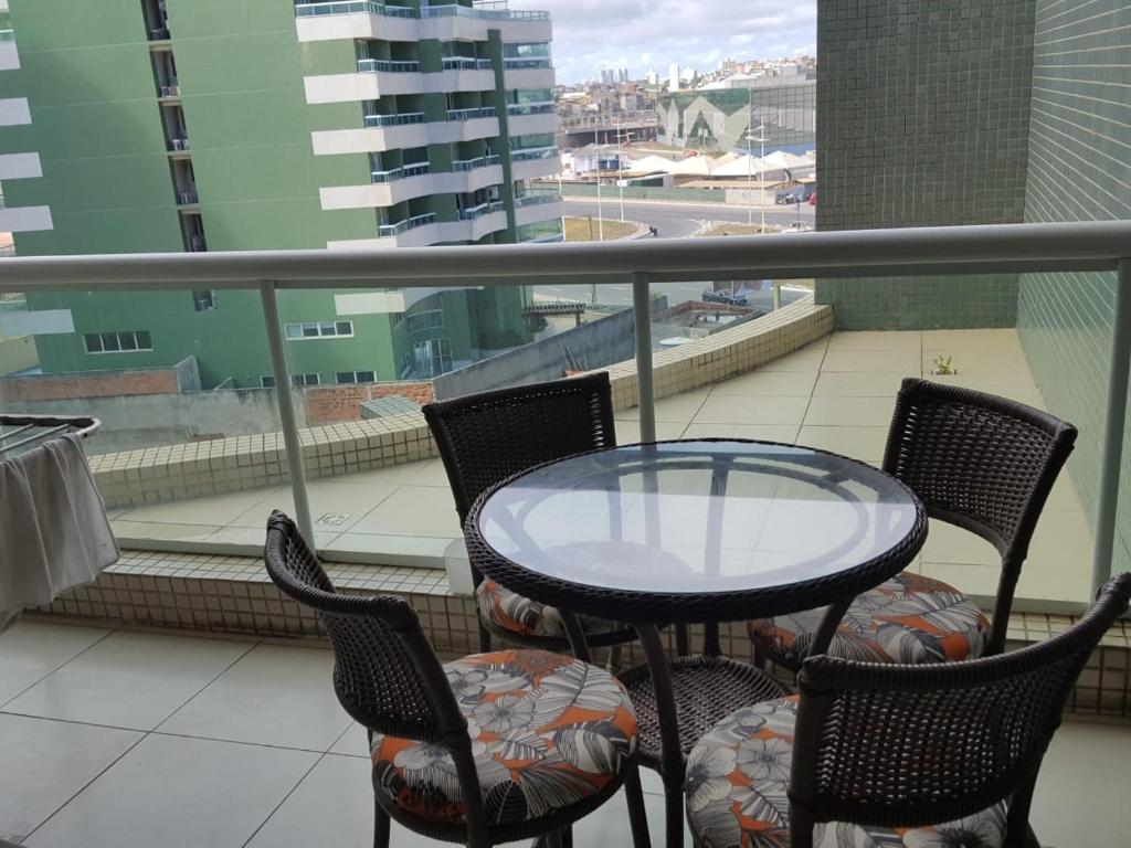 una mesa y sillas en un balcón con vistas en 1/4 MOBILIADO EM FRENTE À PRAIA, EM SALVADOR BAHIA, en Salvador