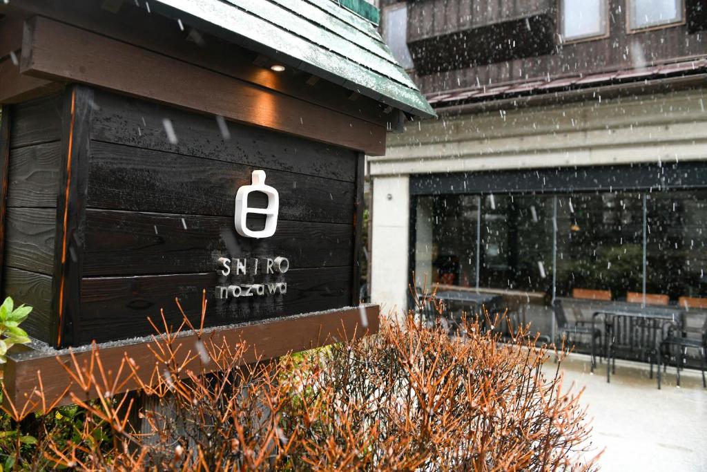 a store with a sign on the side of a building at Shiro Nozawa in Nozawa Onsen