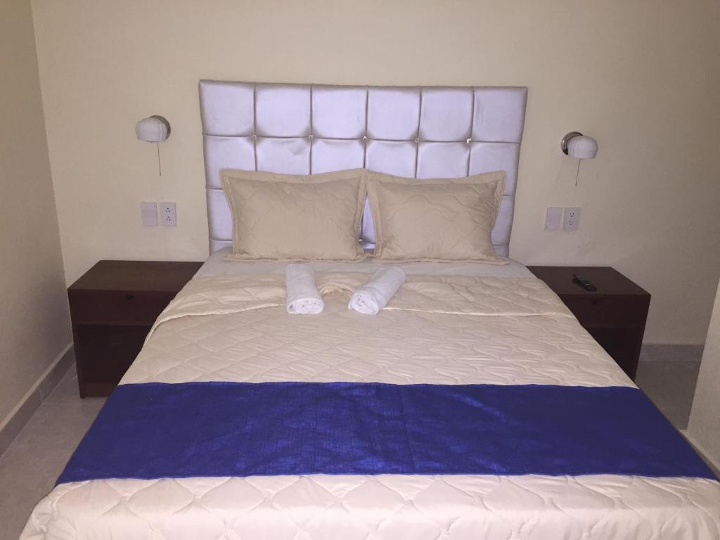 1 cama grande con 2 zapatillas encima en Hotel Cotubanama Samaná, en Santa Bárbara de Samaná