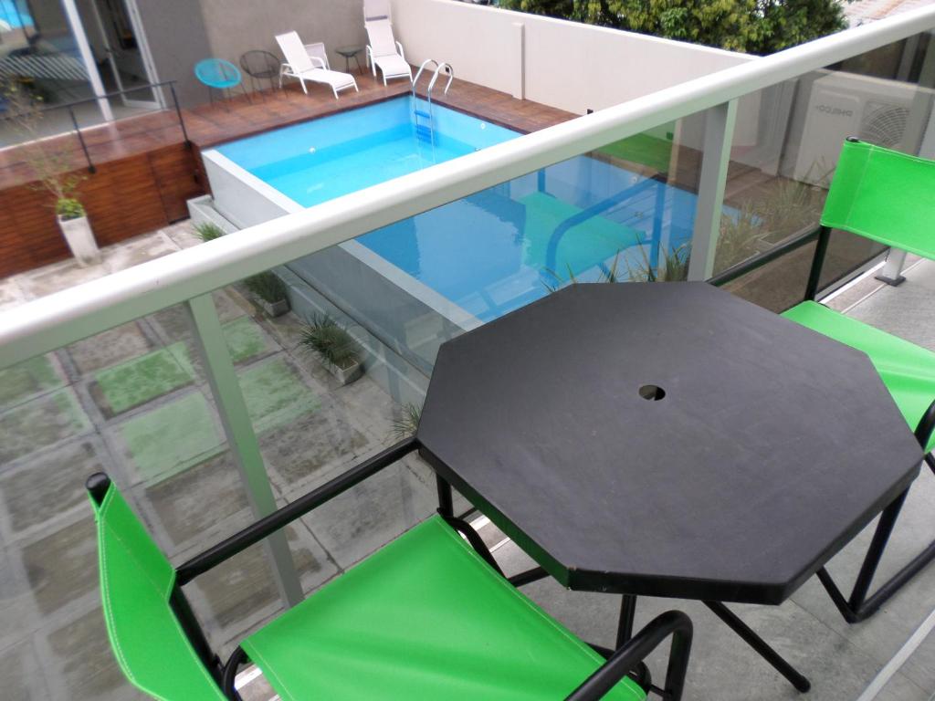 薩爾塔的住宿－departamento salta argentina，一个带桌椅的阳台和一个游泳池