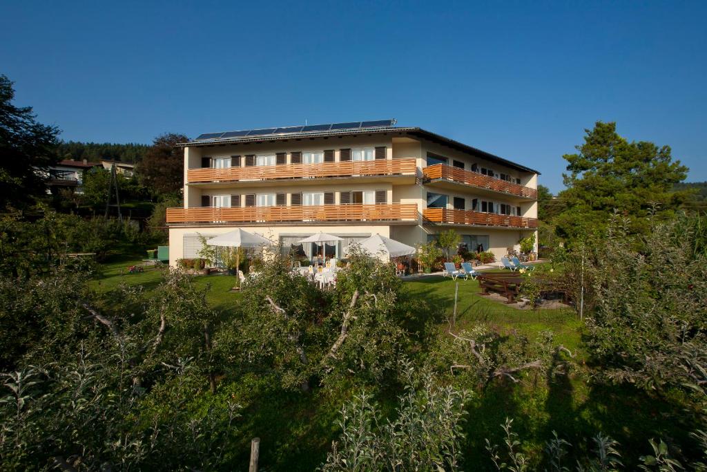 ein großes Gebäude mit Rasen davor in der Unterkunft St. Oswalderhof in Pörtschach am Wörthersee