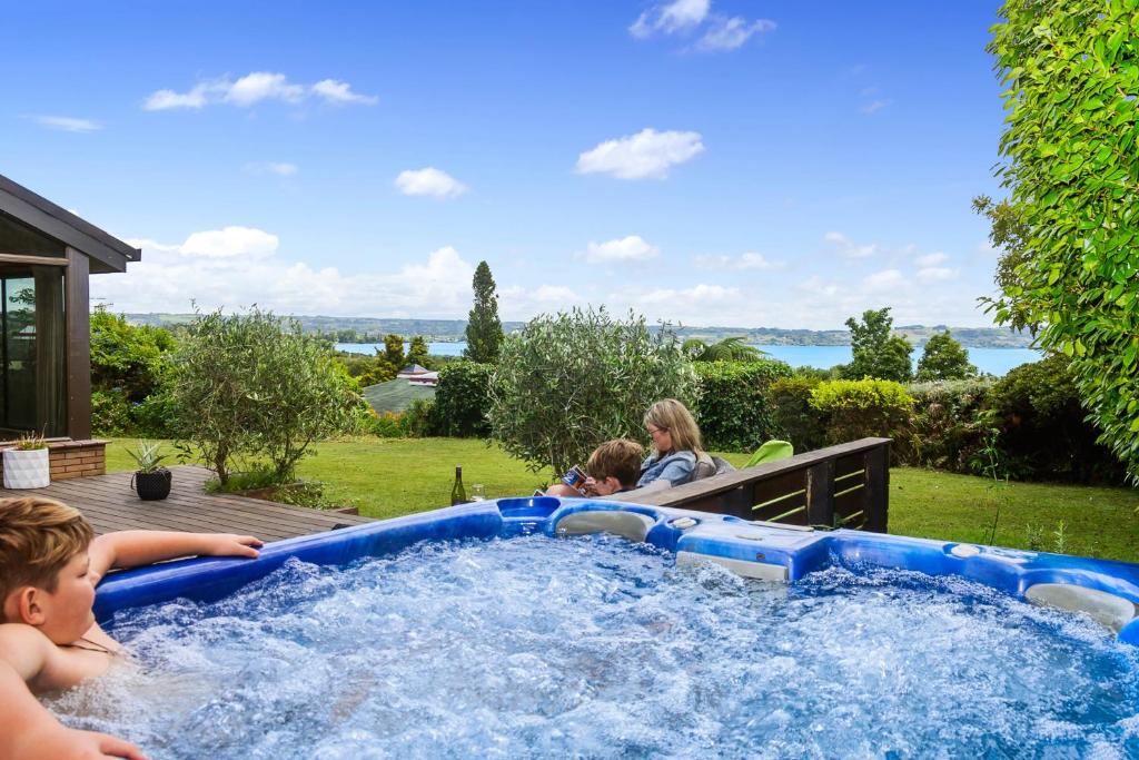 a group of children playing in a hot tub at The Bird House - Kawaha Point, Rotorua. Stylish six bedroom home with space, views and relaxed atmosphere in Rotorua