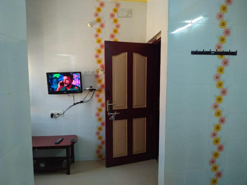Pokój z drzwiami i telewizorem na ścianie w obiekcie New Regency w mieście Ćennaj