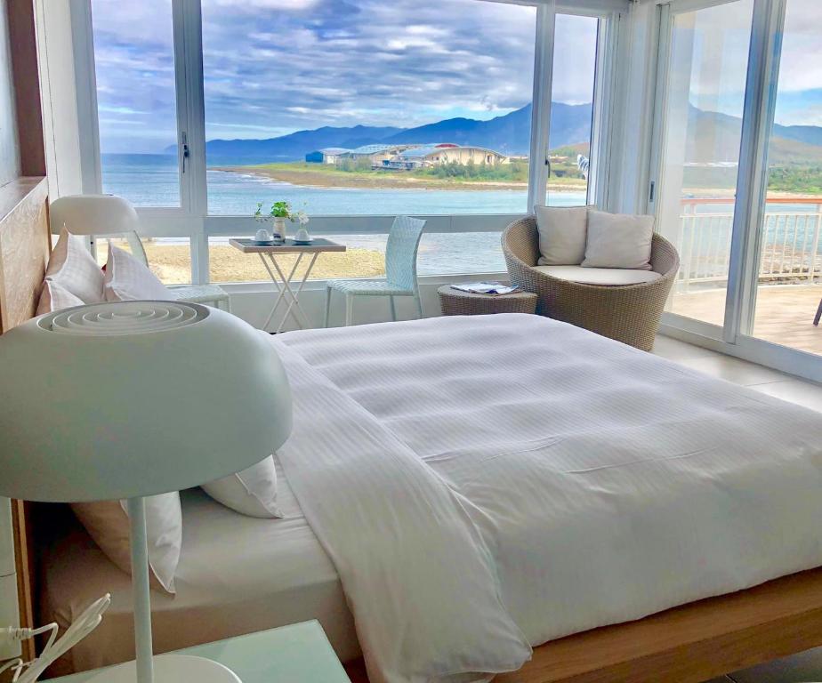 um quarto com uma cama e vista para o oceano em Blue Ocean Sunny BS em Checheng