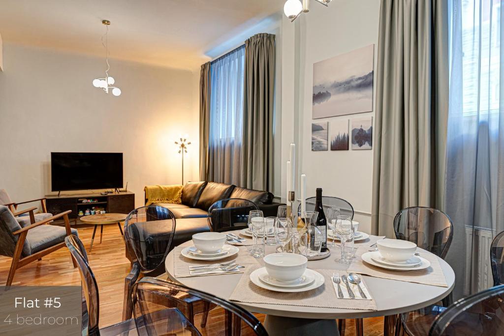 uma sala de estar com uma mesa com cadeiras e um sofá em Dandelion Apartments Stabu em Riga