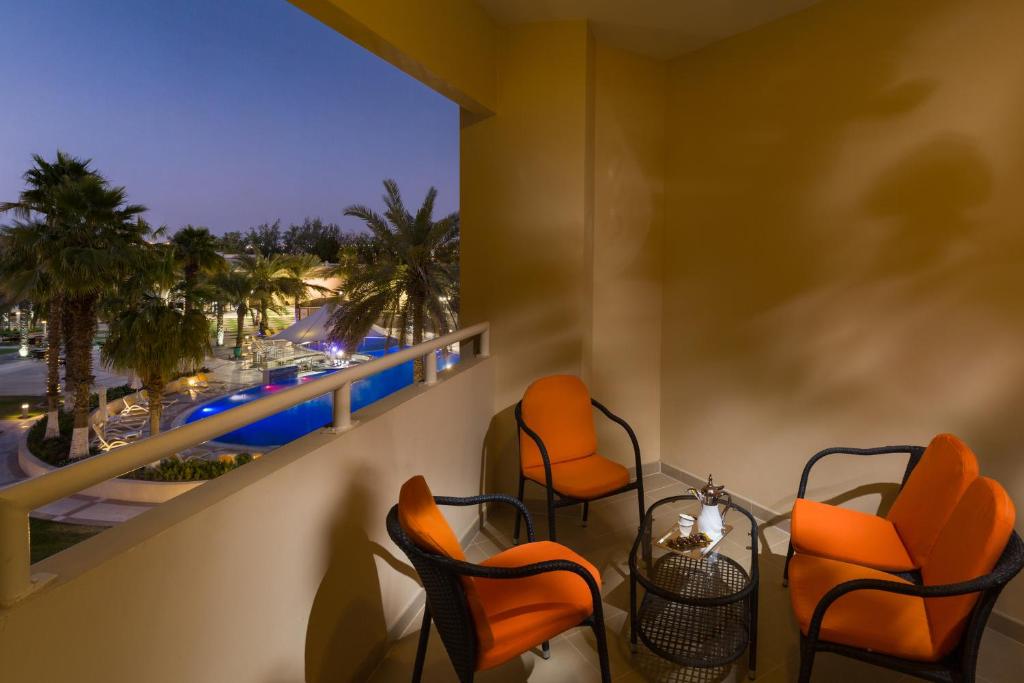 a balcony with chairs and a view of the ocean at Metropolitan Al Mafraq Hotel in Abu Dhabi
