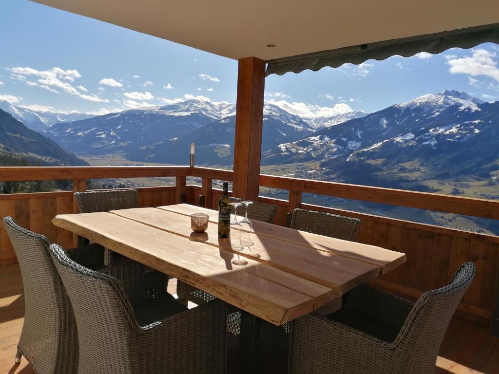 a wooden table and chairs on a balcony with mountains at Ferienwohnung La-Wurm in Hart im Zillertal