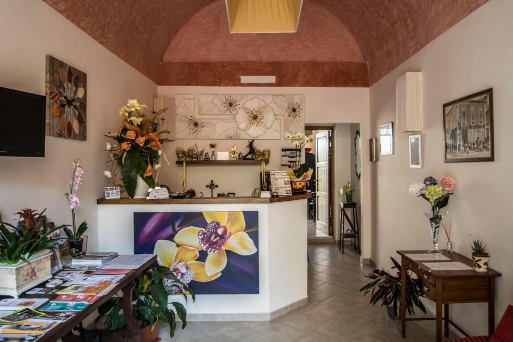 una stanza con bancone e fiori sul muro di Locanda dei Fiori a Pistoia