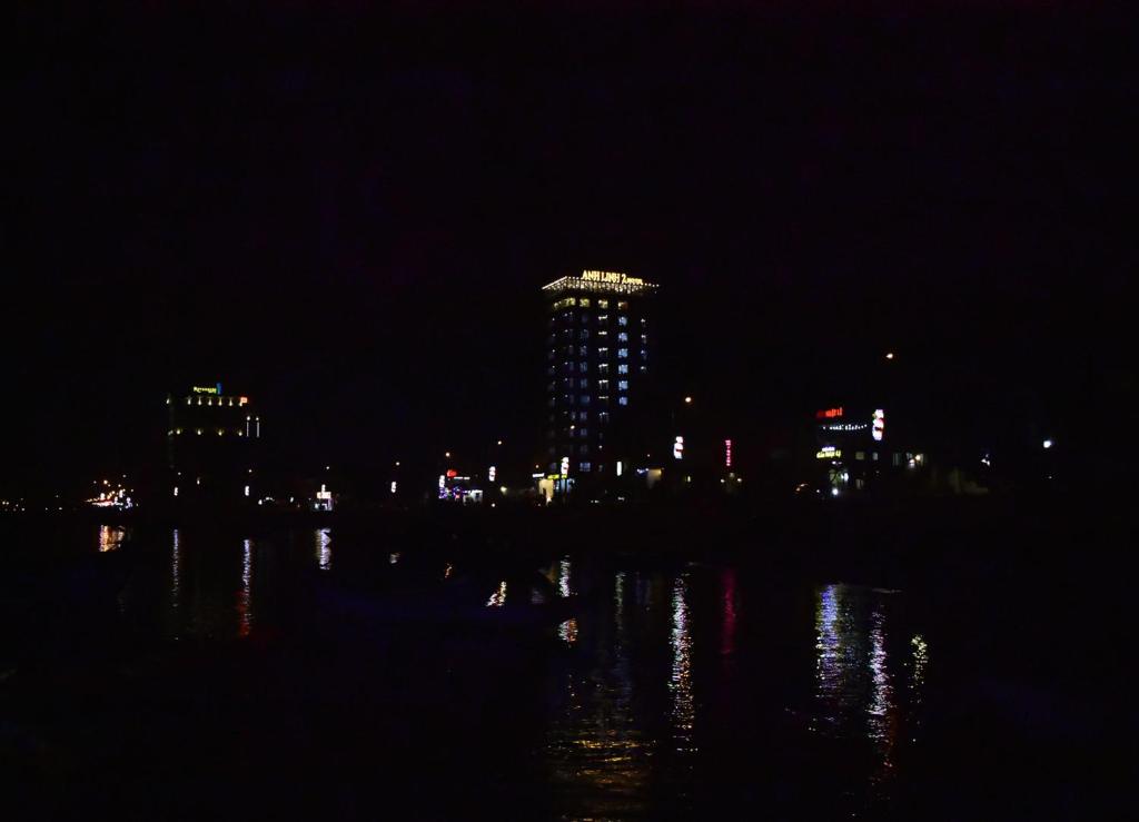 Una ciudad iluminada por la noche con un edificio en Anh Linh 2 Hotel en Ðồng Hới
