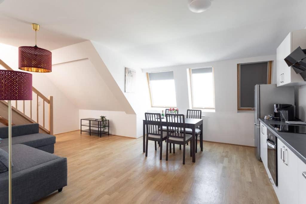 eine Küche und ein Wohnzimmer mit einem Tisch und Stühlen in der Unterkunft Penthouse bei Schönbrunn mit Dachterasse! N44 in Wien