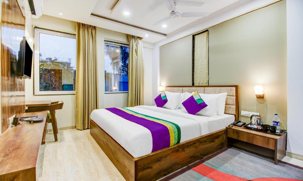 a bedroom with a bed and a desk and a window at Treebo Trend The Pavilion in Nagpur