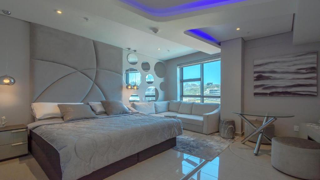 1 dormitorio con 1 cama grande y 1 sofá en Pearls Lux - Inland facing, en Durban