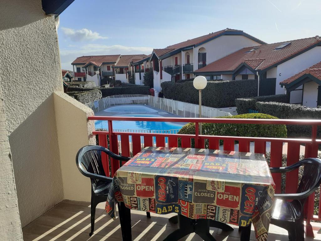 a table and chairs on a balcony with a pool at Appartement Santocha in Capbreton