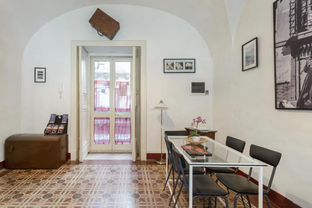 uma sala de estar com mesa e cadeiras em Da Gianni e Lucia Rooms with bathroom in the city center em Catânia