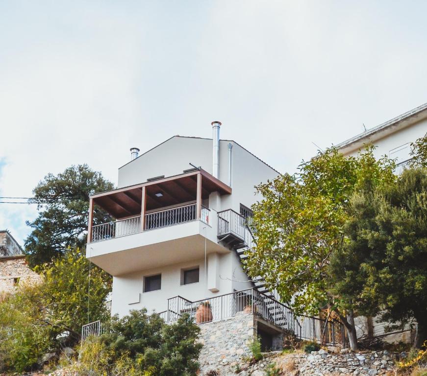 a white building with stairs on the side of it at Athivoli Elegant Apartments in Káto Metókhion