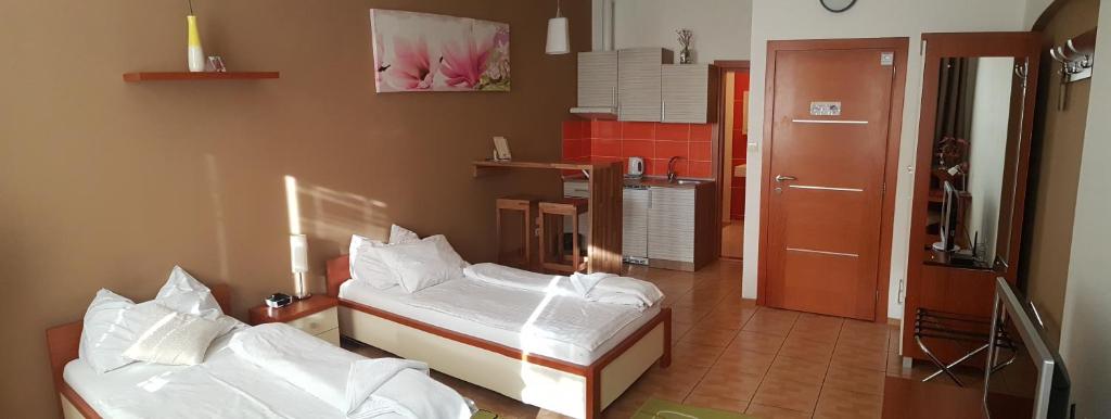 a room with two beds and a kitchen at Alex Pension in Prešov