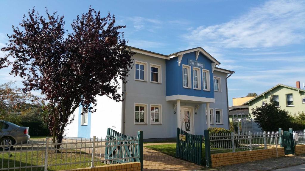 een blauw-wit huis met een hek bij Uns Huesung in Ahlbeck