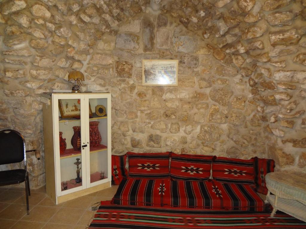 a room with a stone wall with a red bench at Jaffa Gate Hostel in Jerusalem