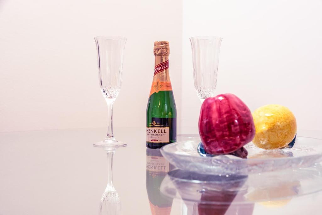 eine Flasche Champagner und zwei Weingläser auf dem Tisch in der Unterkunft Senator Flats Petrus & Kardinal Nagl in Wien