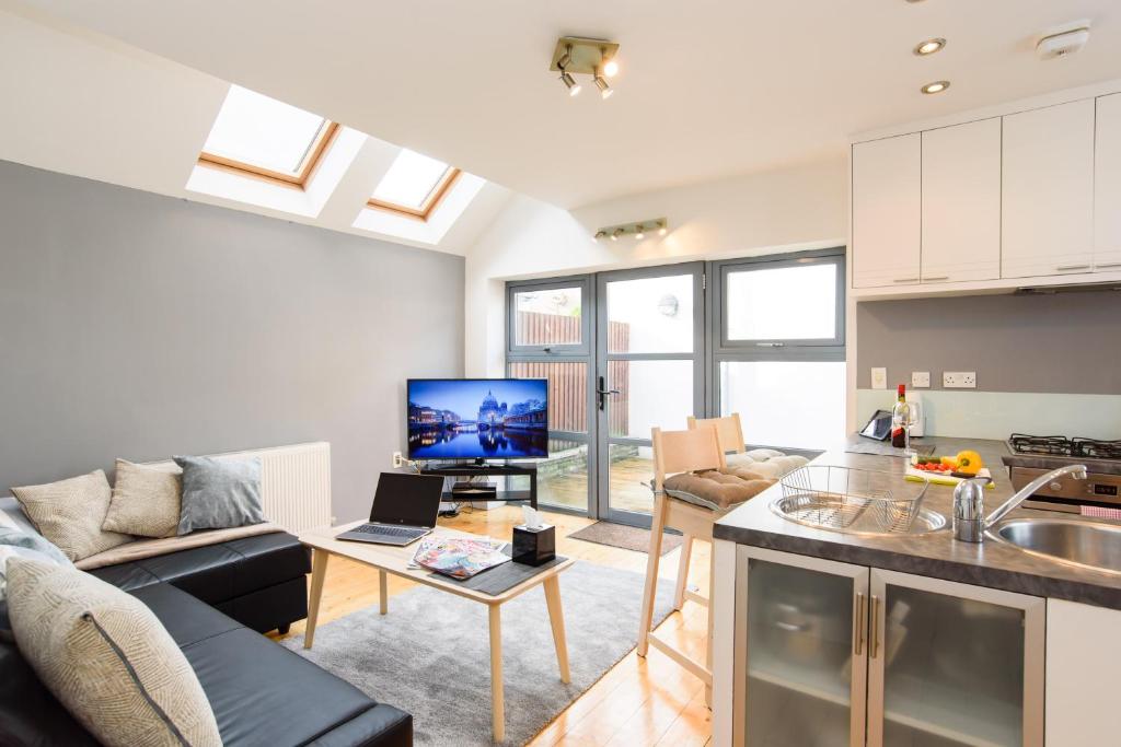 uma cozinha e sala de estar com um sofá e uma mesa em City Retreat, 2 Bed House with Cloudstream Hot Tub em Cardiff