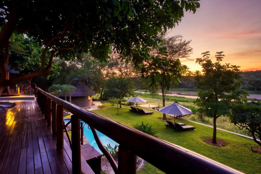 a view from a deck of a resort with a pool at Emhosheni River Lodge in Balule Game Reserve