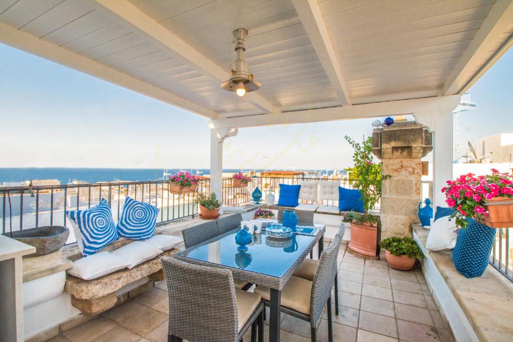 a patio with a table and chairs on a balcony at Trulli&Dimore - Casa Reina in Polignano a Mare