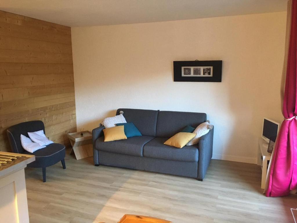 sala de estar con sofá azul y silla en Studio calme et apaisant en Saint-Jean-dʼAulps