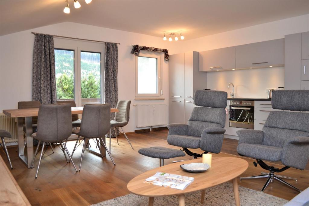 salon ze stołem i krzesłami oraz kuchnia w obiekcie Ferienwohnung mit Seeblick, Unterach am Attersse w mieście Unterach am Attersee