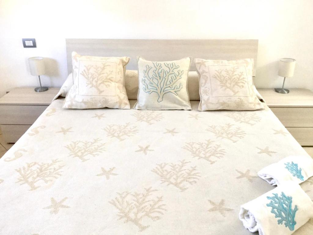 una camera da letto con un grande letto bianco con cuscini di Berenice a Rio Marina
