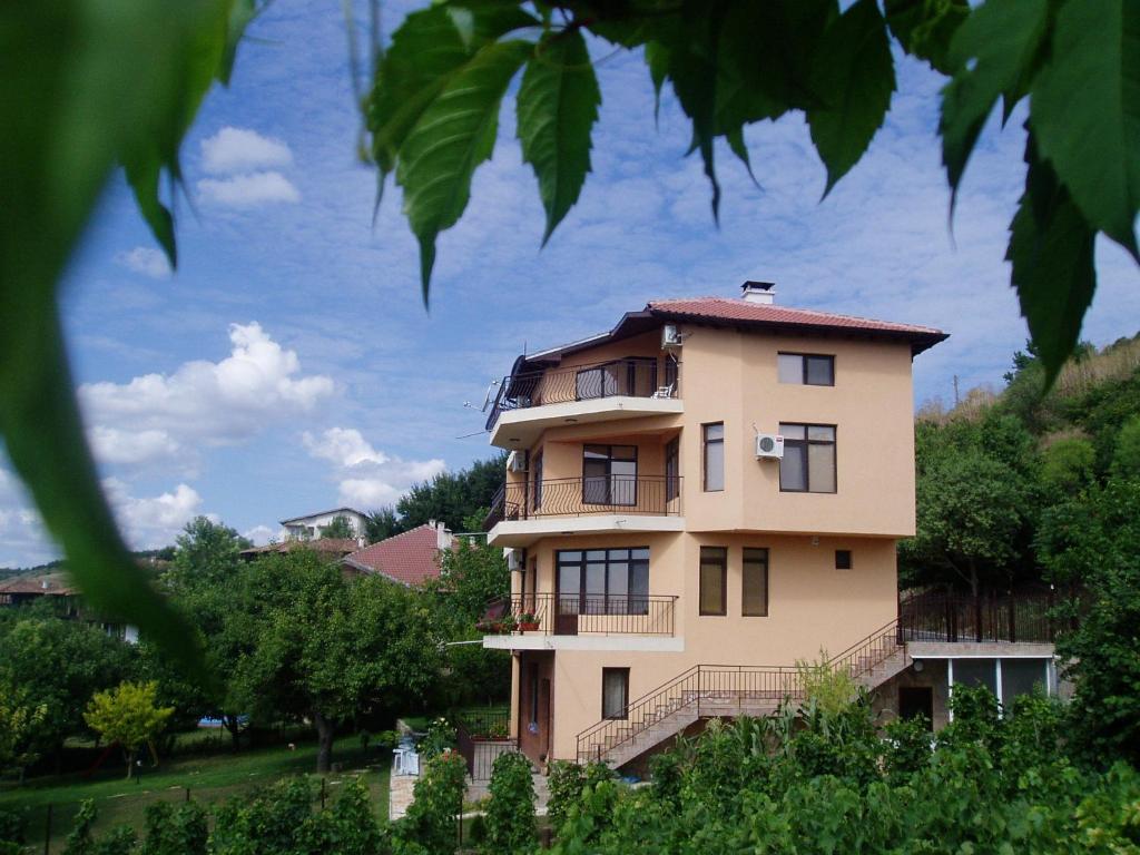 ein gelbes Gebäude mit Balkon auf einem Hügel in der Unterkunft Villa Prolet in General-Kantardzhievo