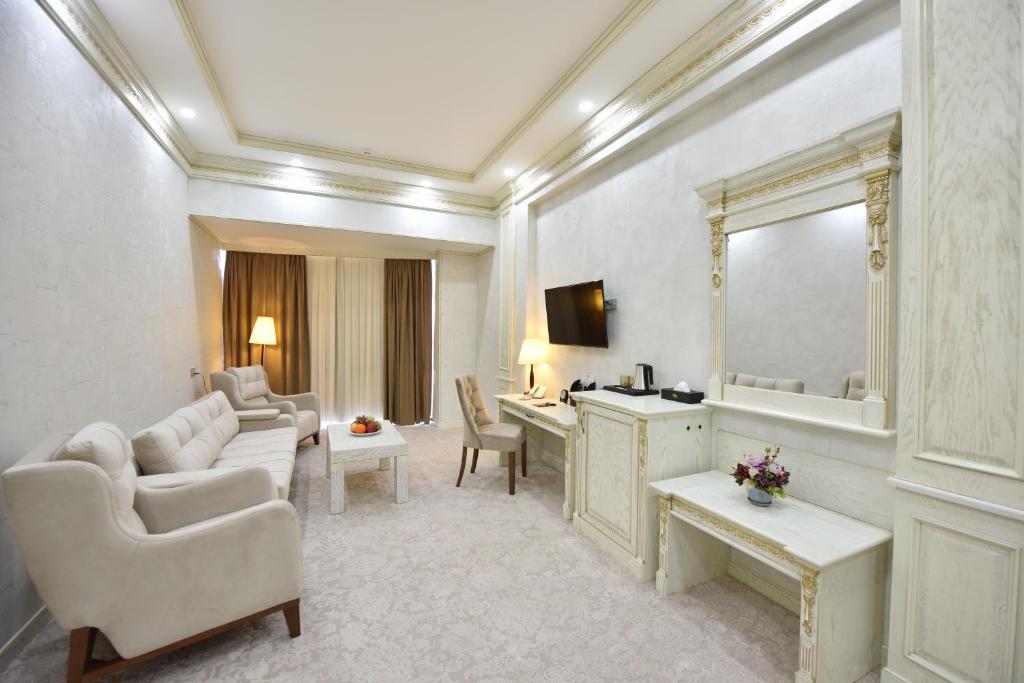 een woonkamer met een kaptafel en een spiegel bij Qushbegi Plaza Hotel in Tasjkent