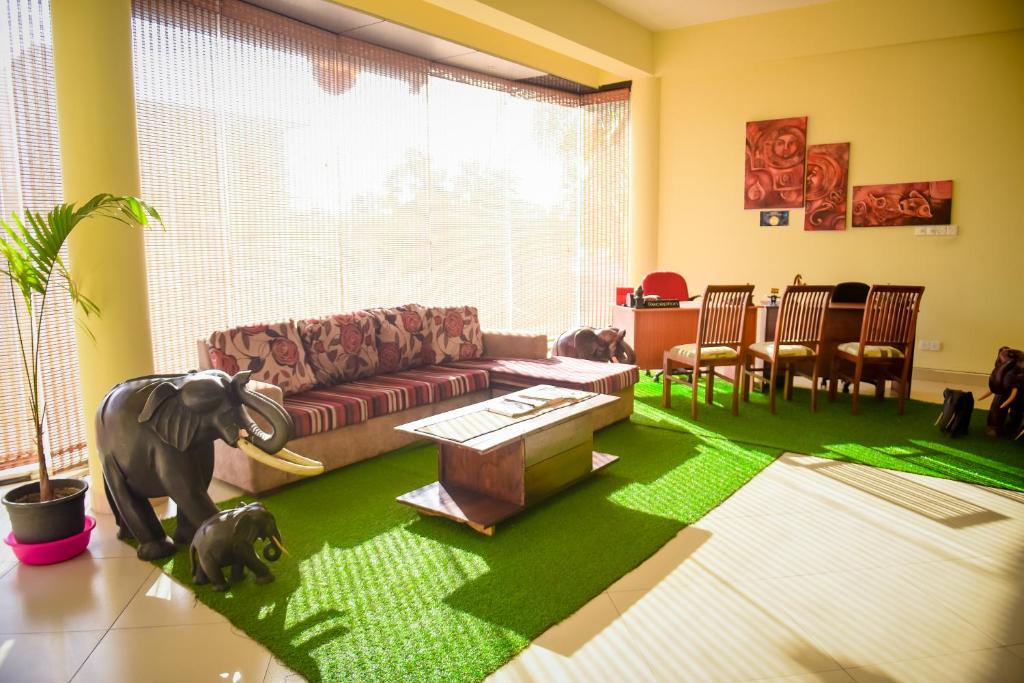 a living room with a couch and a green rug at Hotel Mount Valley & Yala Safari in Tissamaharama