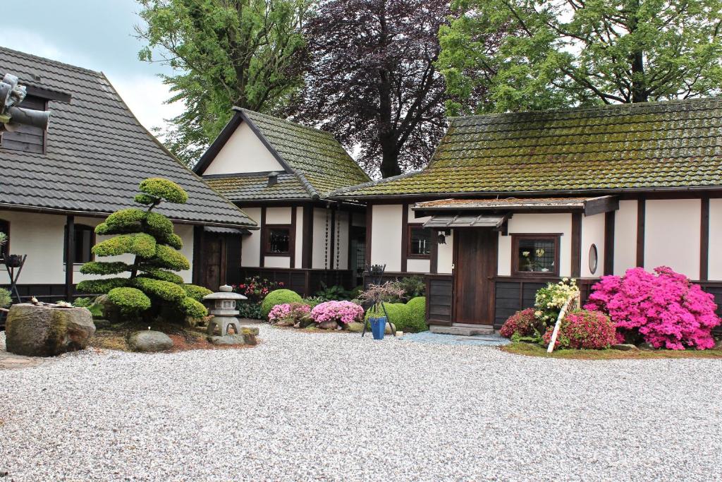 a house with a gravel driveway in front of it at Den Japanske Have B & B in Herning